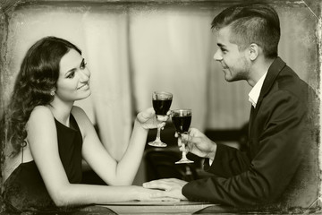 Young couple with wine at restaurant, black and white retro stylization