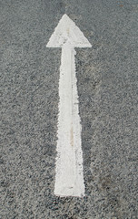A forwarded white arrow on the asphalt road