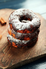 Delicious doughnuts with chocolate icing on table close up