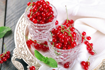 Fresh red currants in glasses on table close up