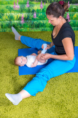 Mother with baby doing gymnastics