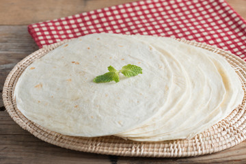 Homemade whole wheat flour tortillas on wooden table.