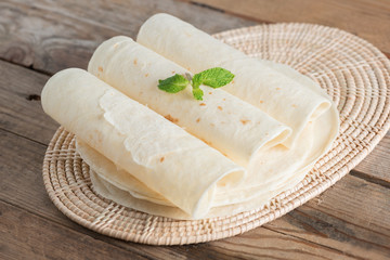 Homemade whole wheat flour tortillas on wooden table.