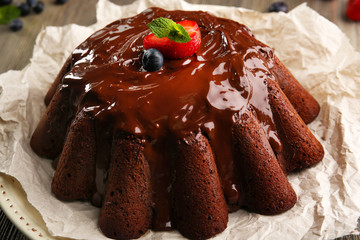 Delicious chocolate cake with berries in plate on table, closeup