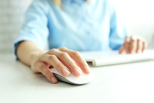 Female hand with computer mouse on table, closeup