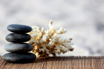 Fototapeta na wymiar Spa stones with coral on sand beach close up
