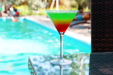 Cocktail on swimming pool background