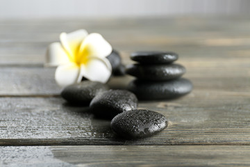 White plumeria flower with pebbles on wooden table