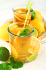 Iced tea with lemon on light wooden background