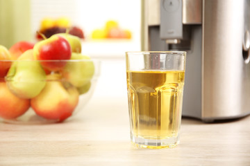 Juicer and apple juice on kitchen table