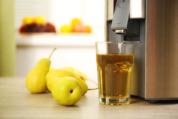 Juicer and pear juice on kitchen table