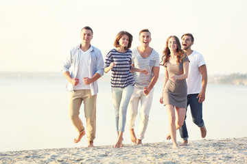 Young people with beer on the riverside