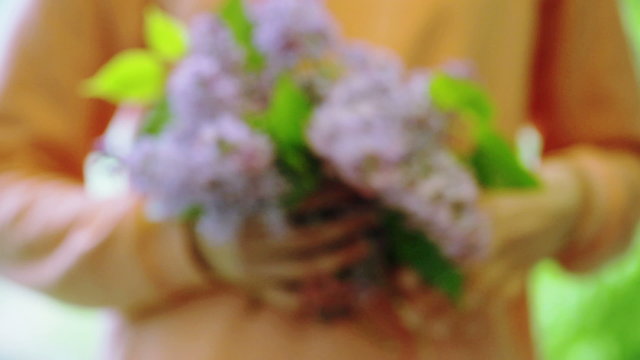 Woman showing bunch of elderflower to the camera
