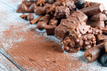 Chocolate sweets with powder on wooden background