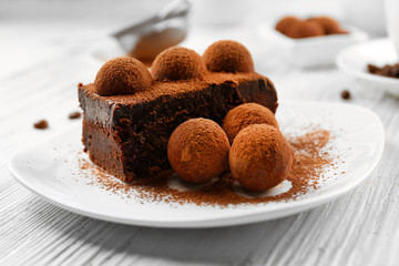 Slice of chocolate cake with a truffle on plate closeup