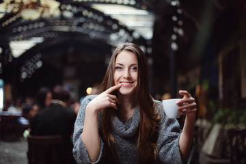 Fototapeta premium Portrait of young beautiful woman drinking coffee in the cafe. 