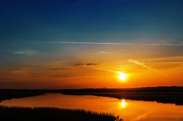 Selbstklebende Fototapete Meer / Sonnenuntergang dark orange sunset over river
