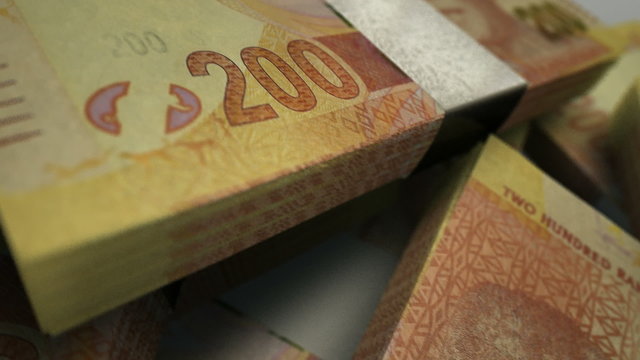 An extreme close up pan of a pile of randomly scattered south african rand banknotes