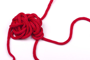 a tangle of matted red rope on a white background closeup