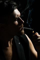Fototapeta premium Bearded man lights up cigarette