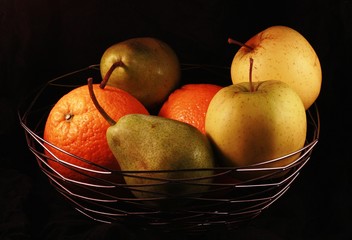 A bowl of fresh fruit on a black background