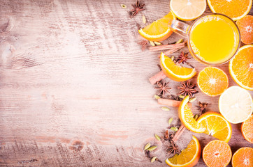 A closeup of a pile of oranges sliced and lemons sliced with spices on wooden background. Eating frame. Free space for text. Christmas