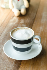 Classic foamy cappuccino in a cup on wood table