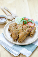 Fired chicken wings on wood plate with thai dip