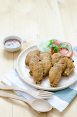 Fired chicken wing on wood plate with thai dip