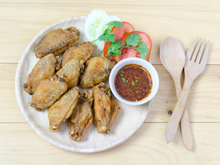 Fired chicken wing on wood plate with thai dip