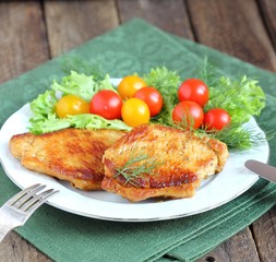juicy grilled pork chop with greens and tomatoes