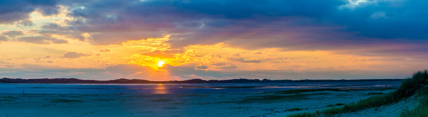 Obraz premium Sunset Ponorama at the beach, Sylt, List, Germany View from Uethoern over the Koenigshafen to List at low tide. In the middle tidal flat and mussel beds. 
