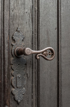 Close up of old weathered door with iron handle