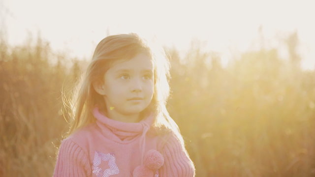 little girl in the rays of the setting sun