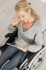 disabled woman on wheelchair using a tablet pc