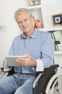 disabled man on wheelchair using tablet pc