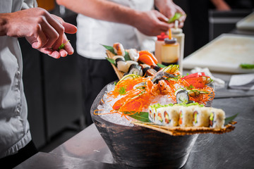 male cooks preparing sushi