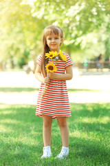 Little girl with sunflowers in the park