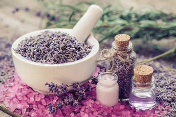 Obraz na płótnie Canvas Dry lavender in mortar, aromatic pink sea salt, cream, bottles o