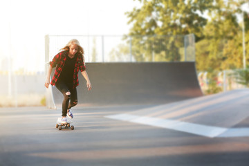 Fototapeta premium Young woman with skating board on the road