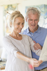 mature couple while painting on a canvas