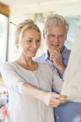 mature couple while painting on a canvas