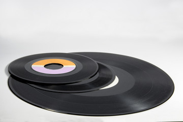 Several vinyl records of different sizes on white background