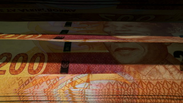 An extreme closeup of south african rand banknotes flipping through in a counting machine