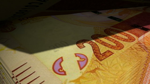 An extreme closeup of south african rand banknotes flipping through in a counting machine
