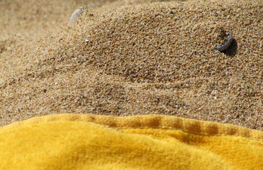 Yellow beach towel on sand