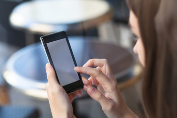 woman holding smartphone with empty screen in hands