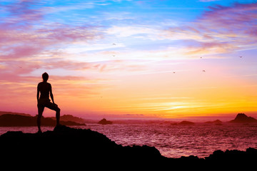 Fototapeta na wymiar wellbeing concept, silhouette of person enjoying beautiful sunset with view of ocean