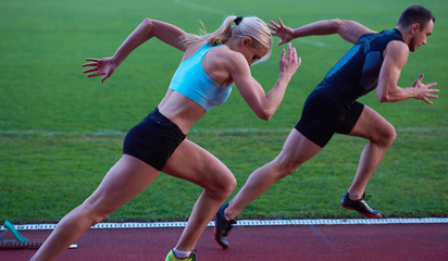 woman group  running on athletics race track from start