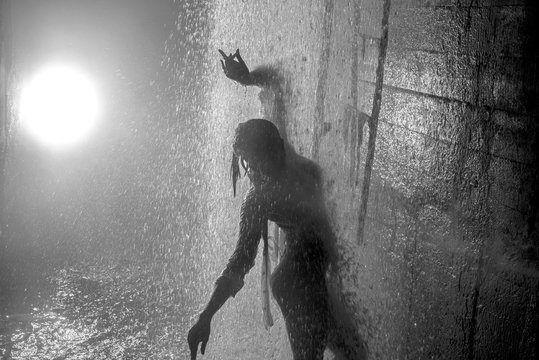 Young girl dancing streams of water in stormwater